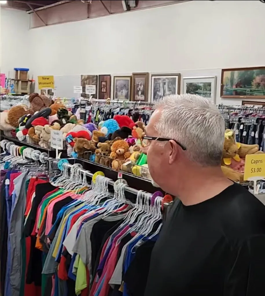 Inside The Blessing Box resale shop — clothing racks, toys, and art on the wall.