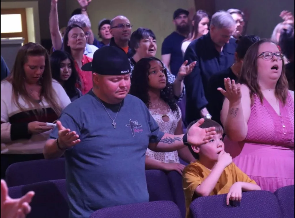 People of every age standing together in worship at The Refuge.