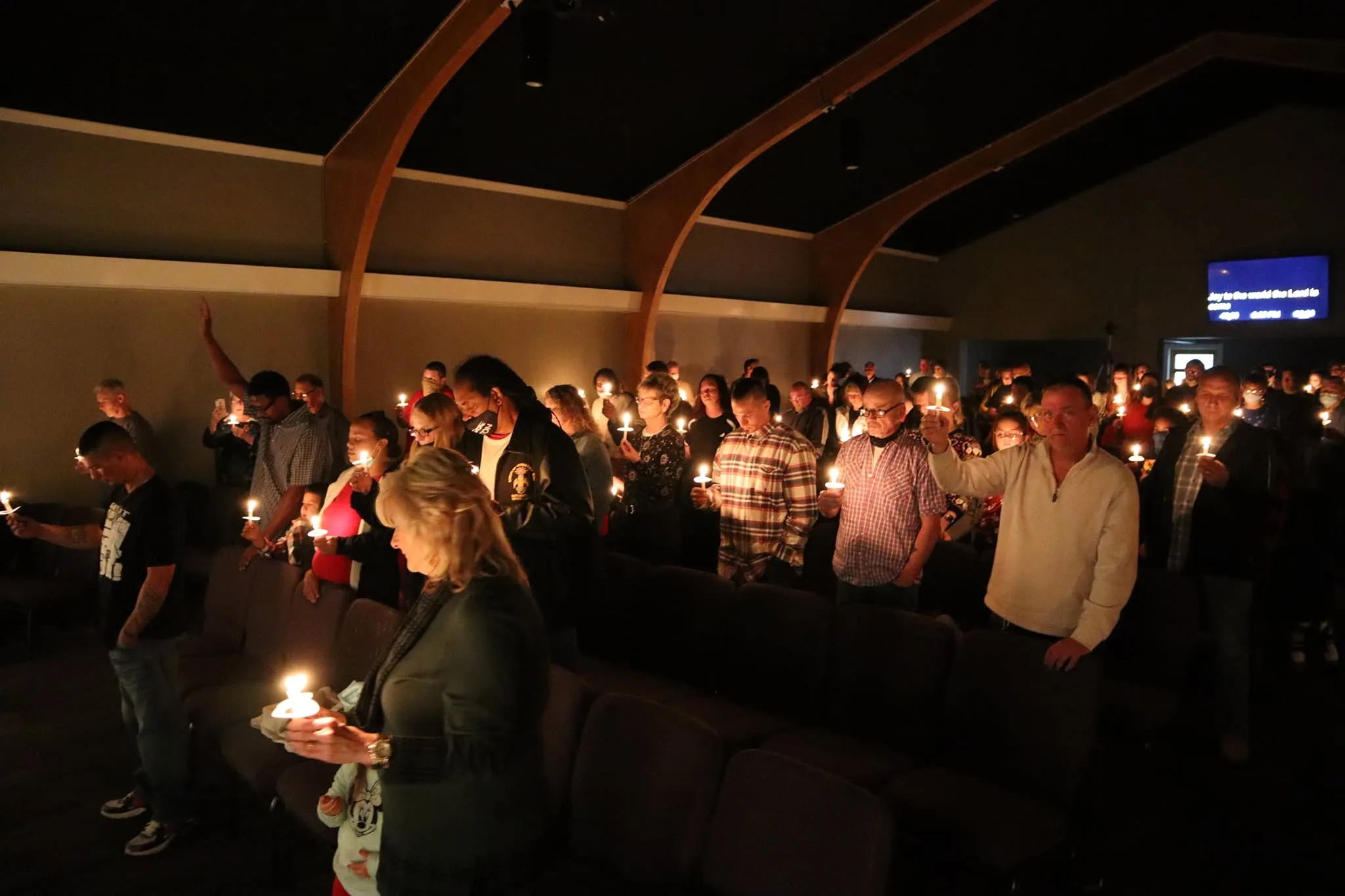 The congregation holding lit candles in the darkened sanctuary on Christmas Eve.