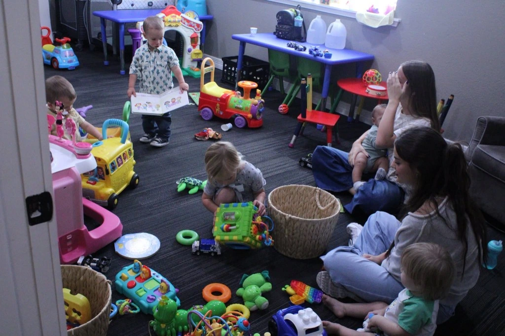 Toddlers and caregivers in The Refuge children’s ministry playroom.