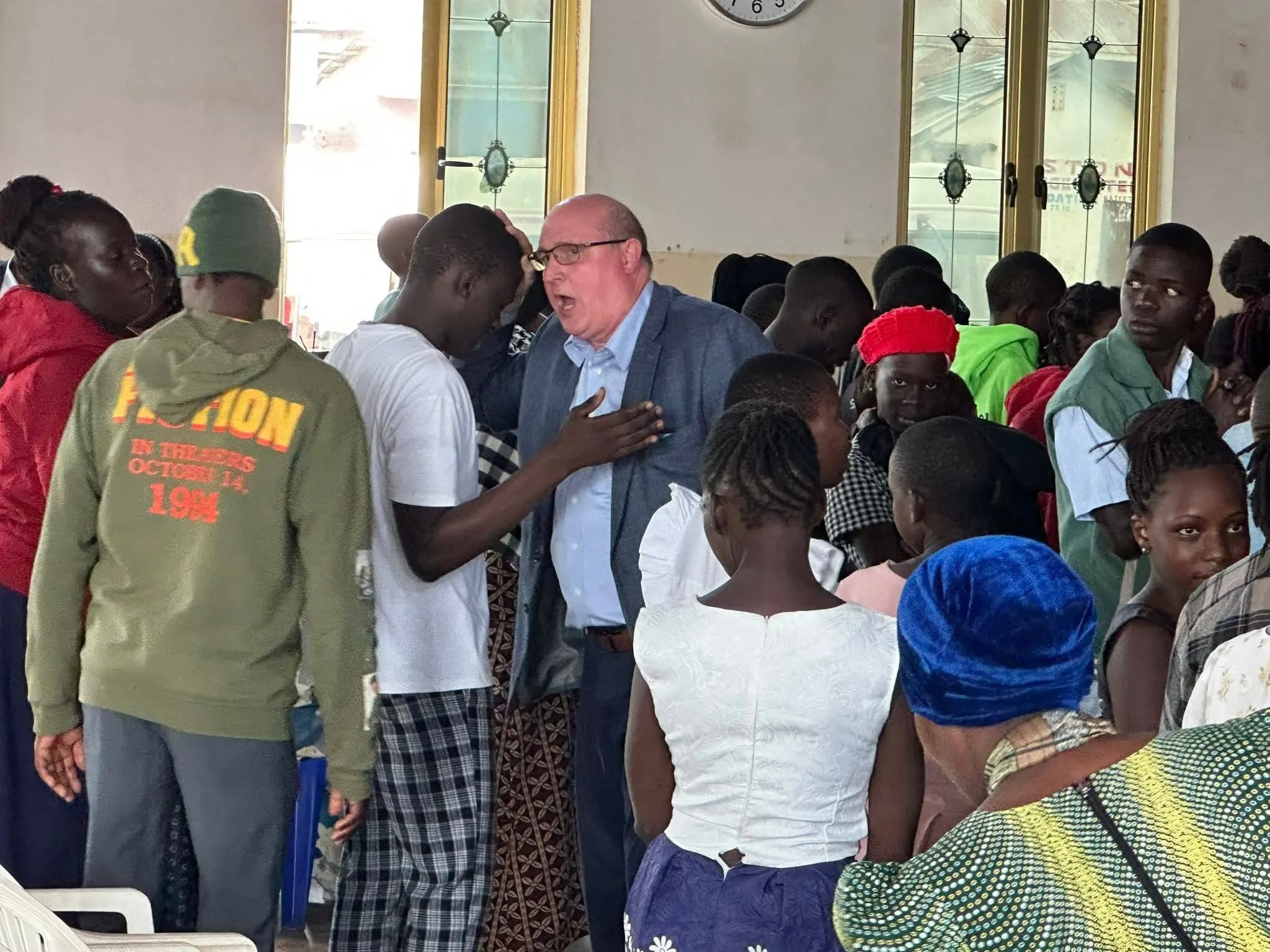 Personal prayer and ministry during a packed mission gathering.