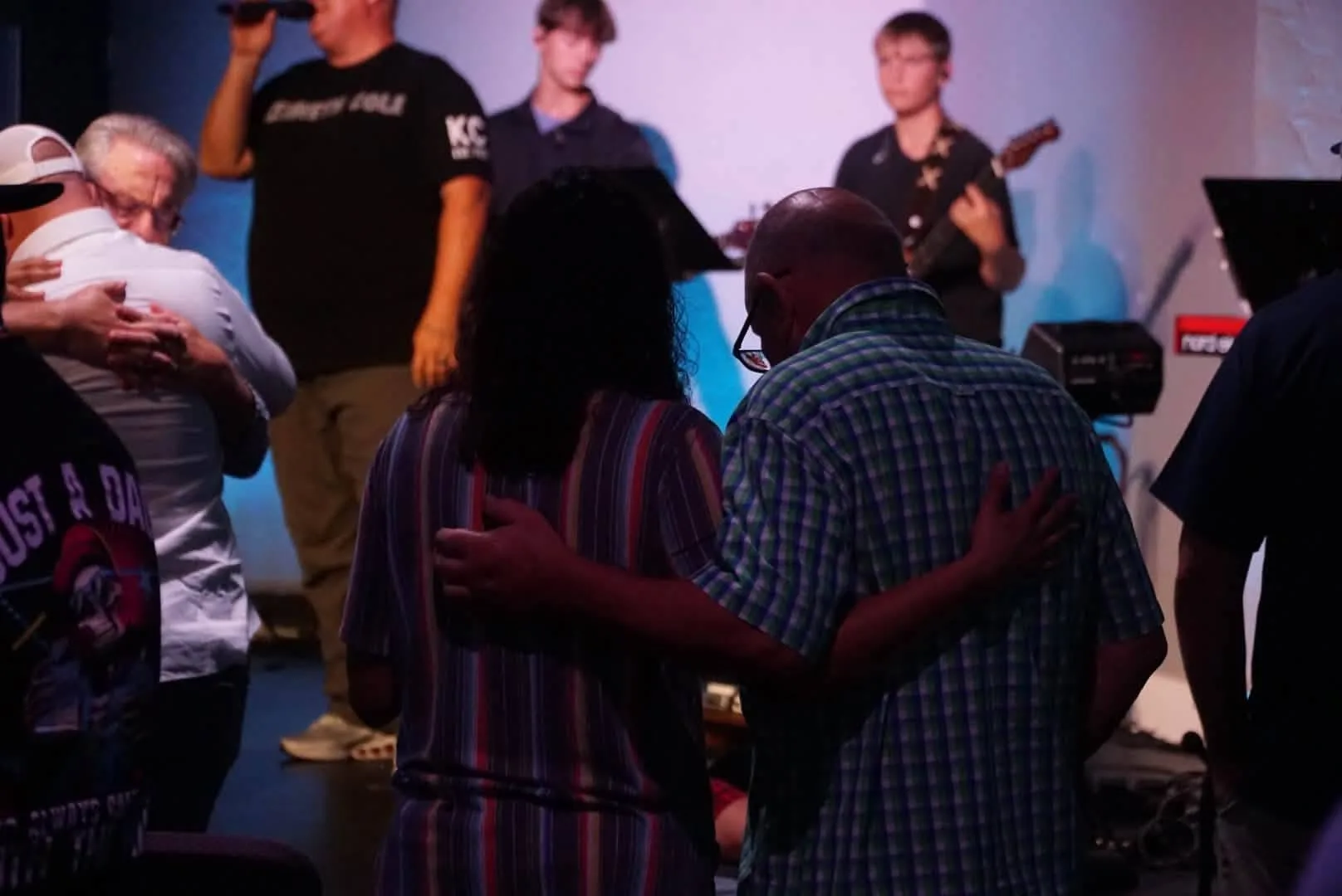 A couple embracing in prayer during worship at The Refuge.