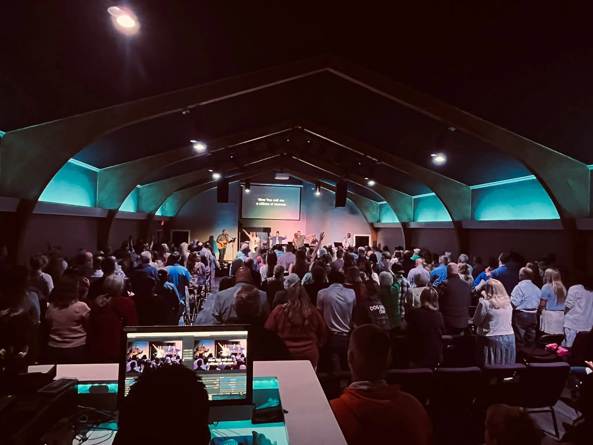 Congregation gathered under the sanctuary arches during worship at The Refuge.